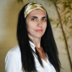 The image features Alessandra Guerrieri, founder AGpress Sustainable Press Office wearing a white long sleeves shirt and a olive patterned silk scarf that holds her hair.